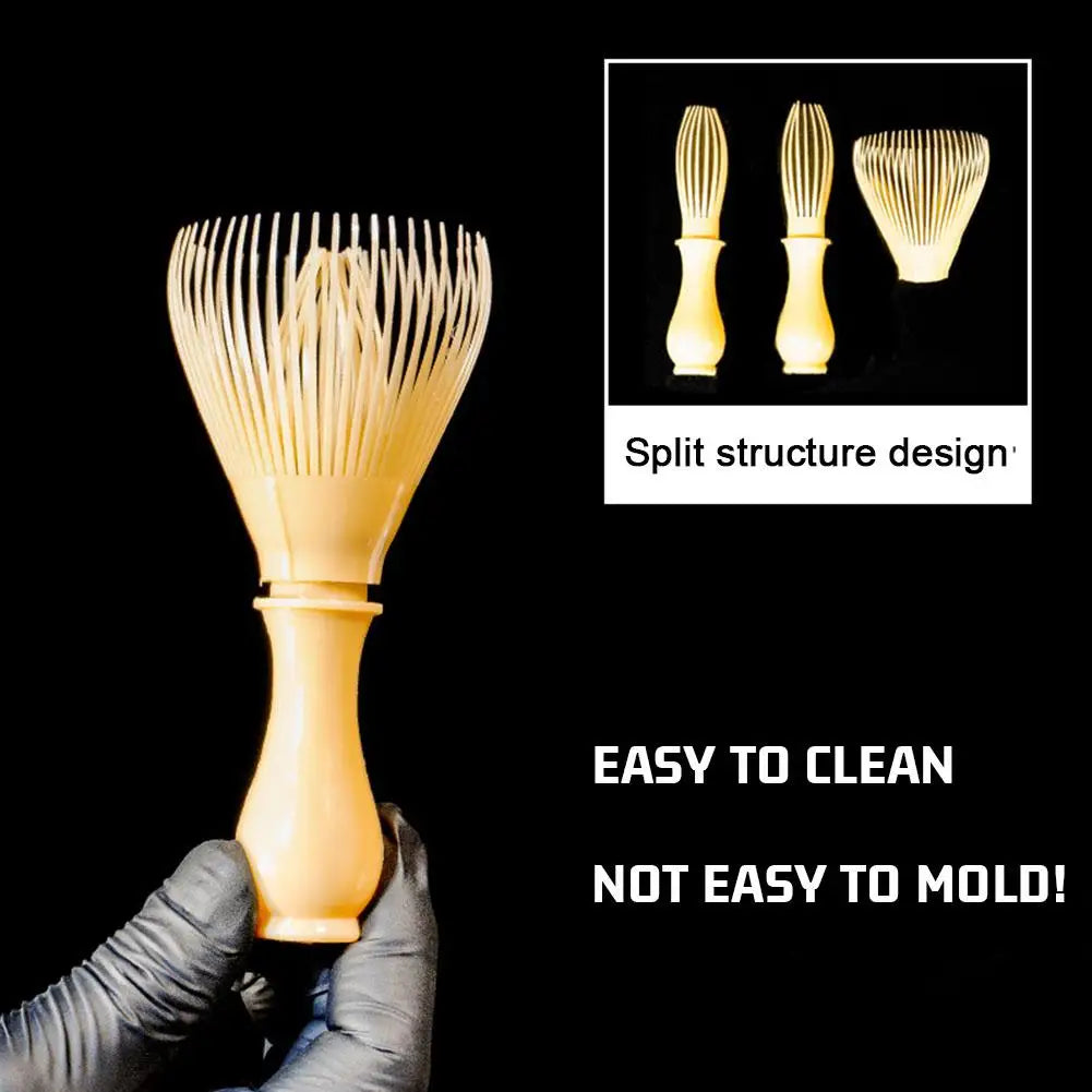 Hairbrush with split structure design held by a gloved hand, on a black background.