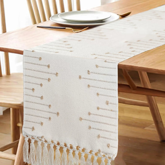 White table runner with gold patterns on a wooden dining table.