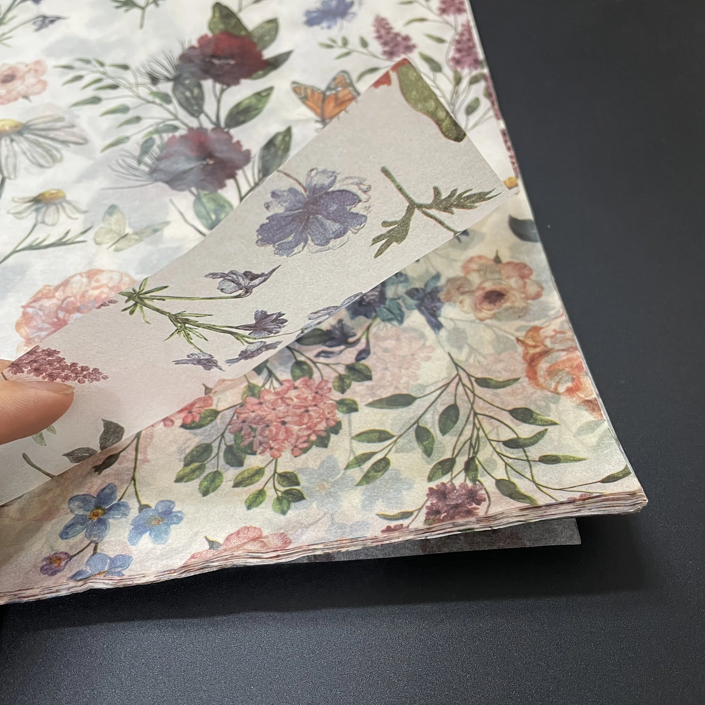 Floral-patterned paper sheets on a dark surface