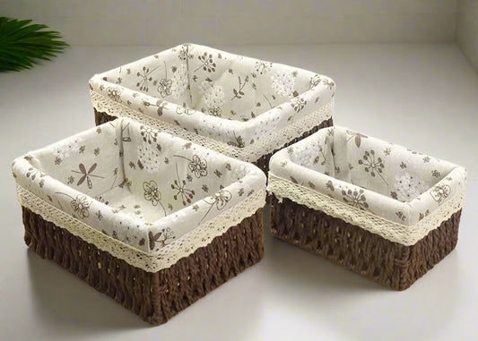 Three square storage baskets with floral fabric liners on a white background