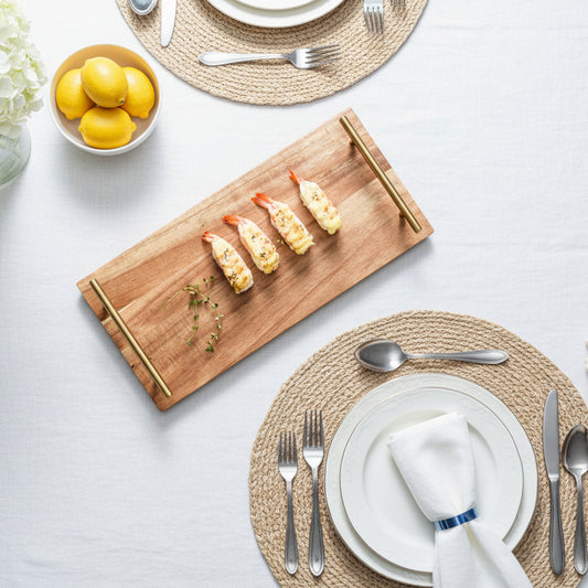 Wooden cutting board with shrimp and a pair of chopsticks on a beige background