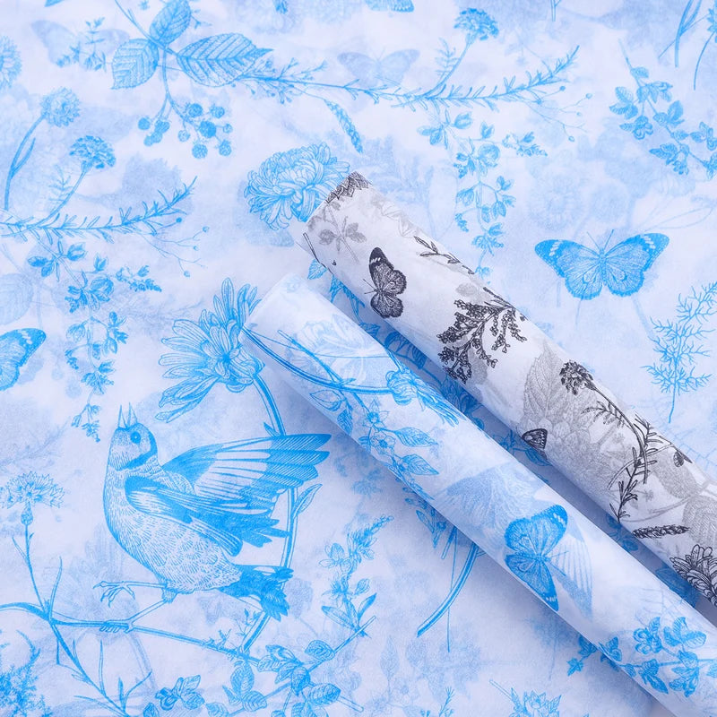 Two rolls of blue and white floral and butterfly patterned fabric.