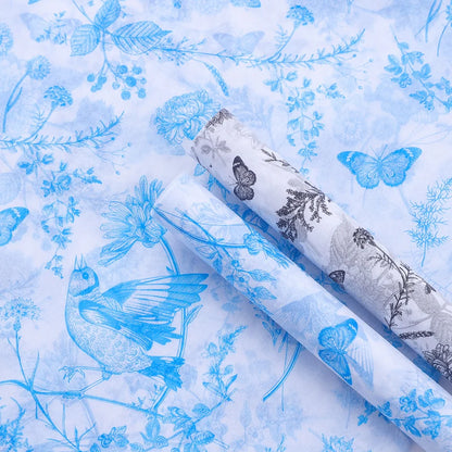 Two rolls of blue and white floral and butterfly patterned fabric.
