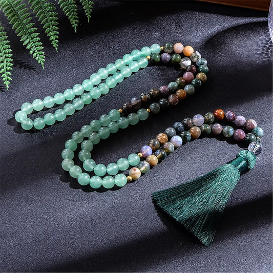 Multicolored beaded necklace with a green tassel on a dark fabric background