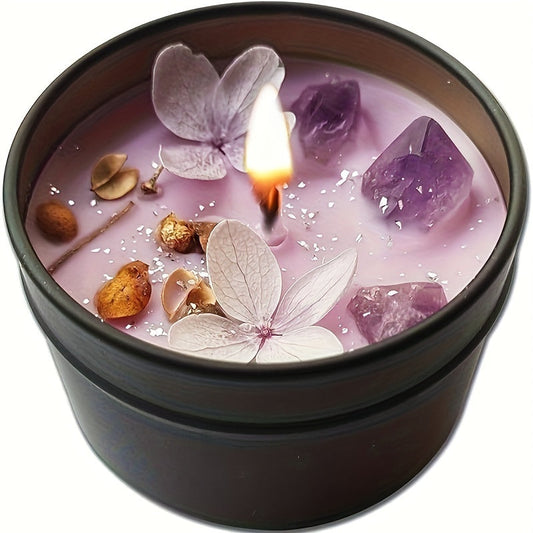Candle in a black container with flowers and crystals on a white background