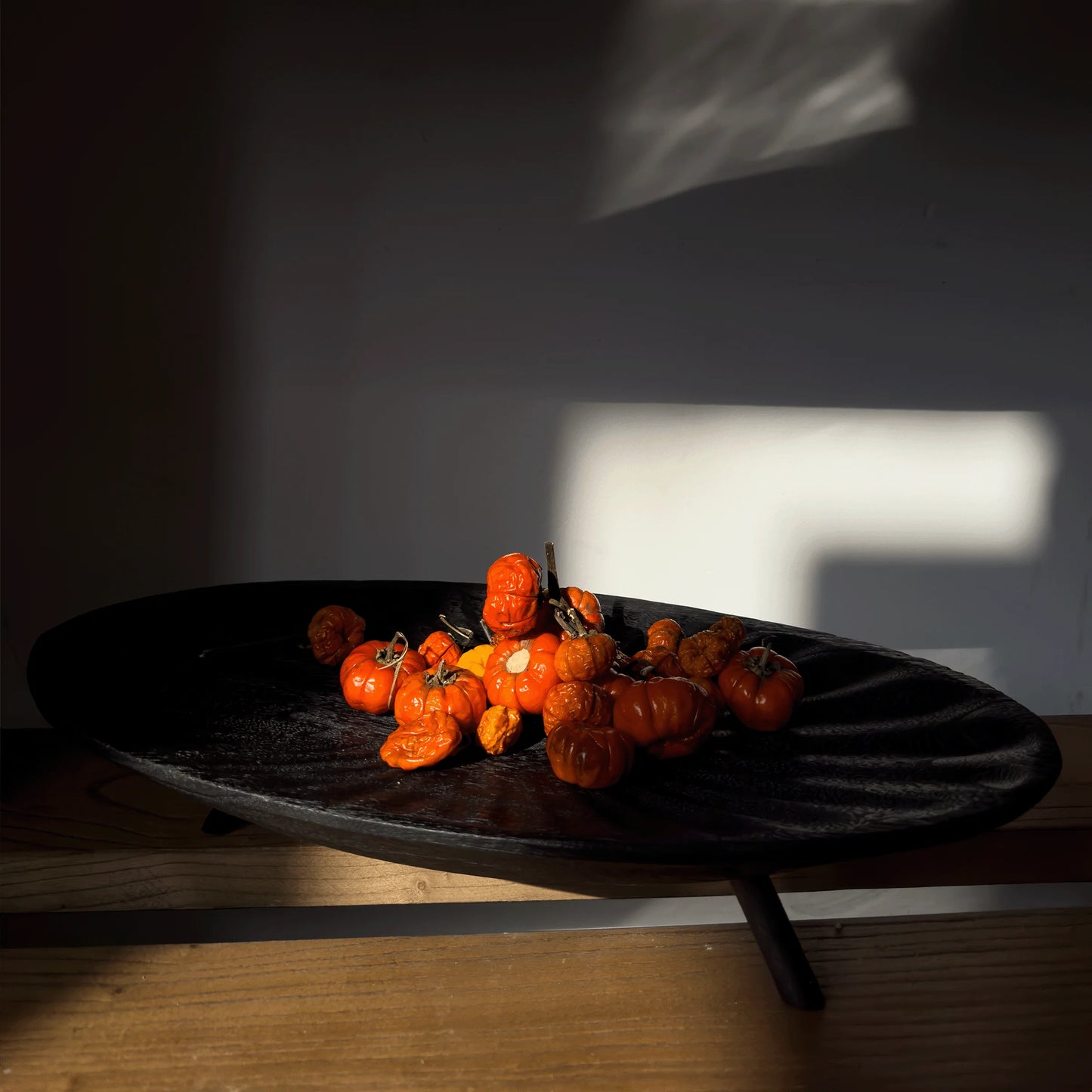 Fermented tomatoes on a black plate with a white 'F' in the background