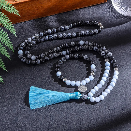 Mala necklace with blue tassel on a dark surface