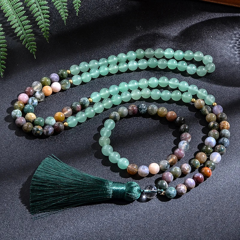 Multicolored beaded necklace with a green tassel on a dark fabric background