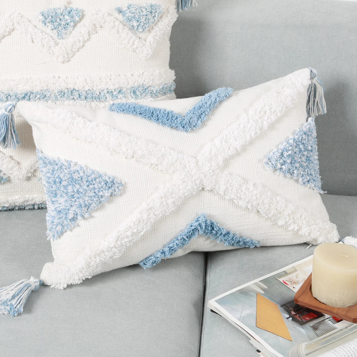 Decorative pillows with blue and white patterns on a gray sofa.