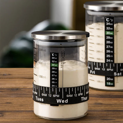 Glass containers with temperature and measurement markings on a wooden surface