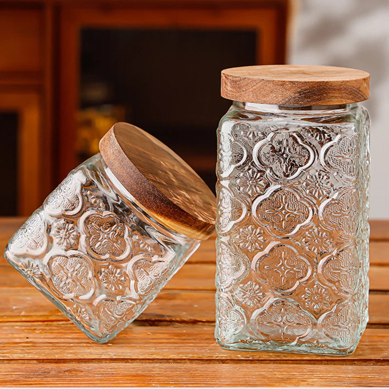 Two glass jars with wooden lids on a wooden surface