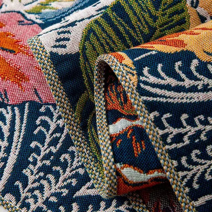 Close-up of a fabric with floral and geometric patterns in blue, orange, and green.