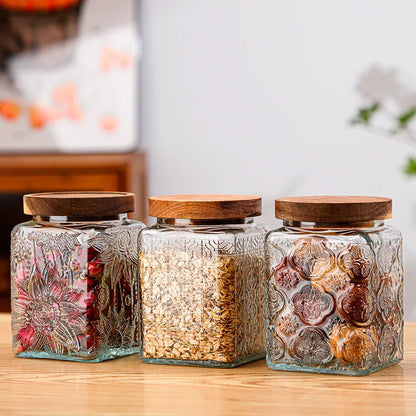 Three glass jars with wooden lids on a wooden surface