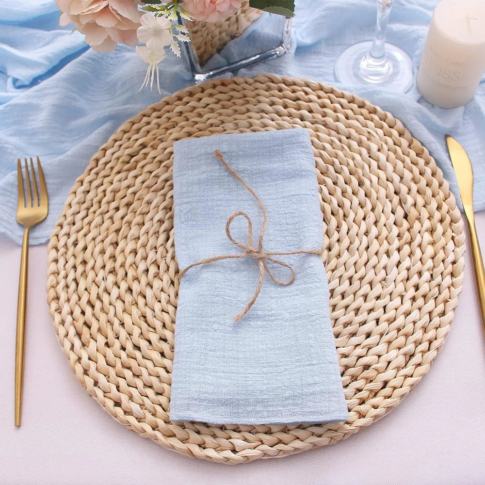 Woven placemat with a light blue napkin, gold fork, and knife on a light blue tablecloth.