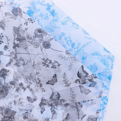 Foil paper with black floral and butterfly designs on a blue and white background