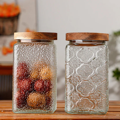 Two glass jars with wooden lids on a wooden surface.