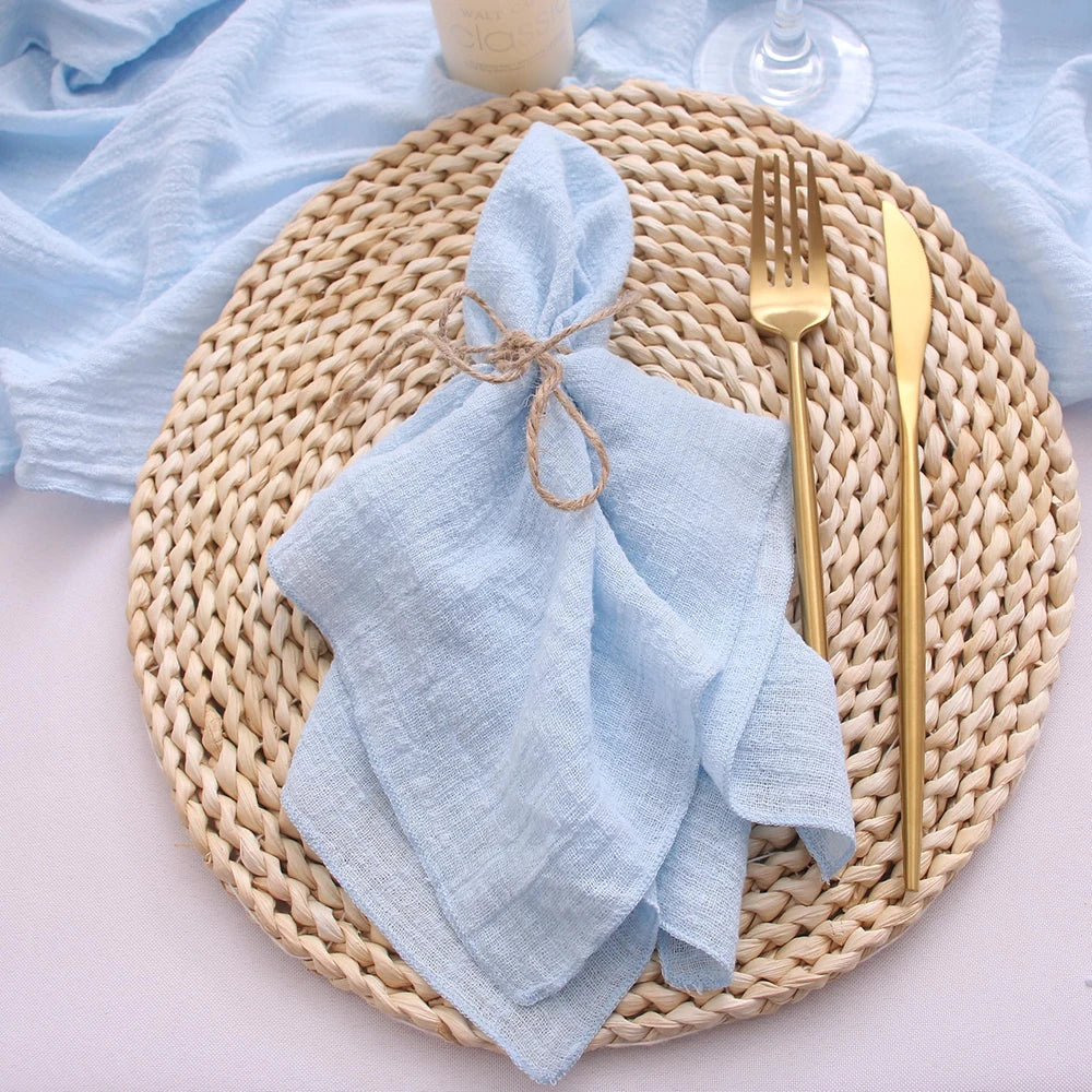 Light blue napkin on a woven placemat with gold fork and knife