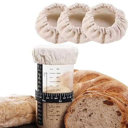 Three beige scrunchies on top of a jar with a bread loaf in the foreground