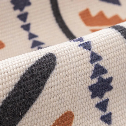 Close-up of a textured fabric with geometric patterns in black, blue, and brown on a beige background.