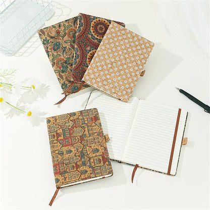 Three patterned notebooks on a white surface with one open to reveal lined pages.