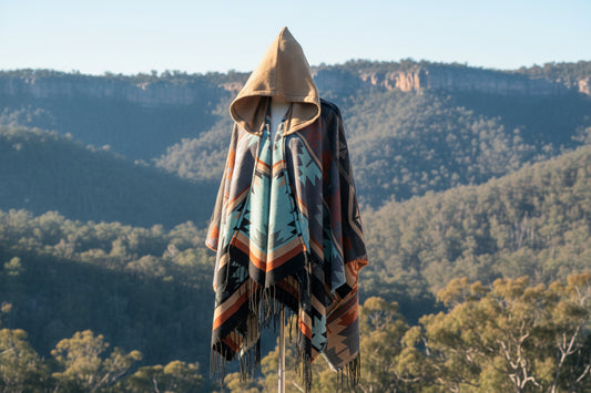 Colorful patterned hooded scarf with fringe on an australian mountain background