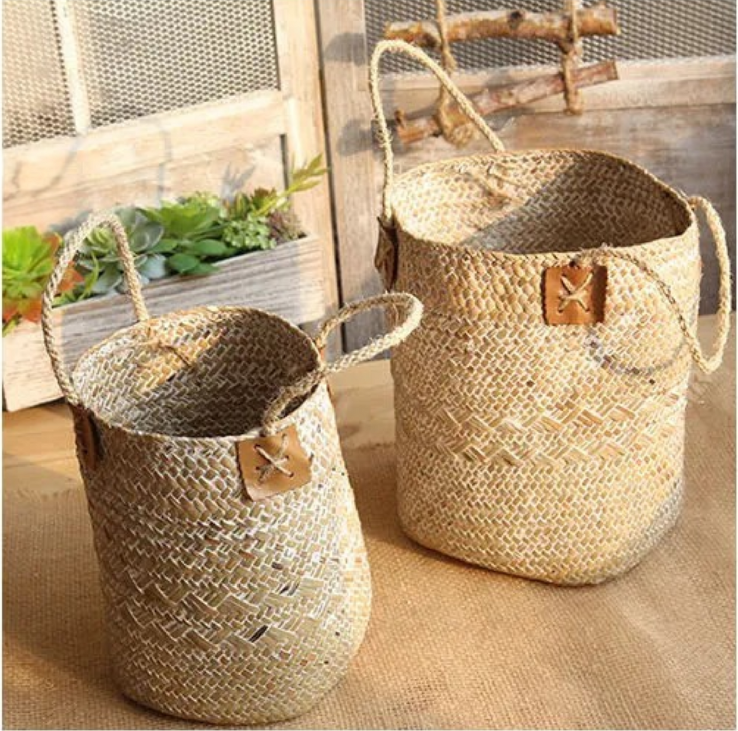Two woven baskets with handles on a wooden floor.