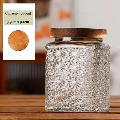 Decorative glass jar with textured design and wooden lid on a wooden surface.