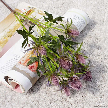 Purple flowers and green leaves on an open magazine with a blurred background