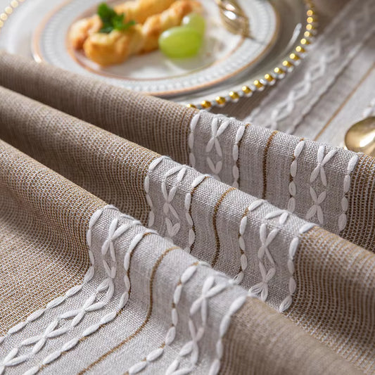 Close-up of a textured tablecloth with intricate patterns on a dining table.