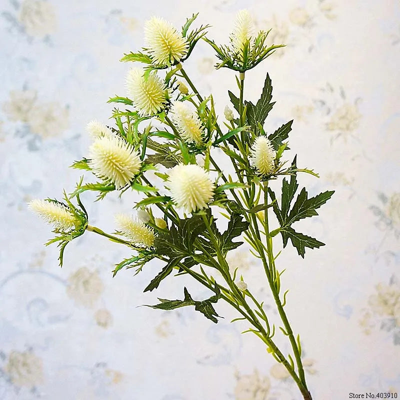 Artificial flower branch with green leaves and white flowers on a light background