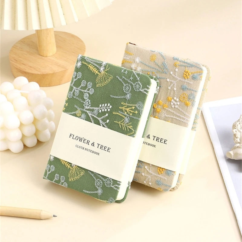 Two notebooks with floral patterns on a light surface