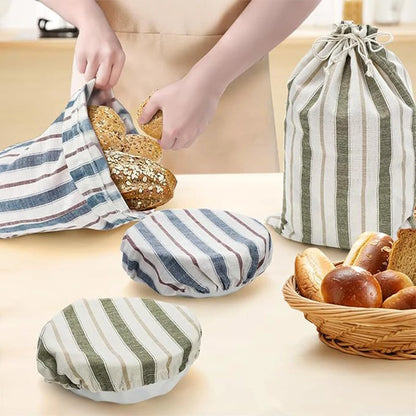 Hands placing bread into striped fabric bags on a wooden surface.