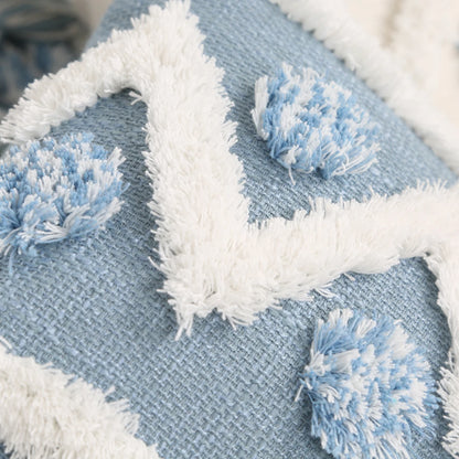 Close-up of a blue fabric with white pom-poms, possibly a decorative item.