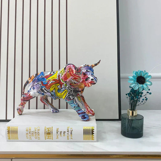 Colorful bull statue on a book with a vase of flowers in the background