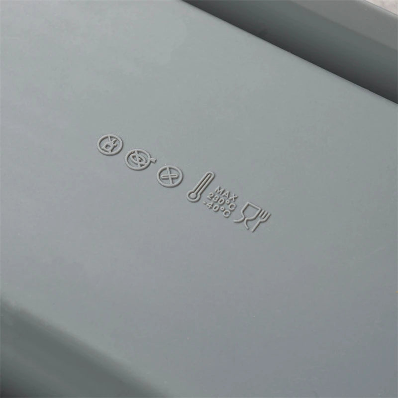 Gray rectangular object with embossed text and symbols on a gray background