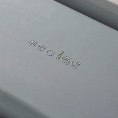 Gray rectangular object with embossed text and symbols on a gray background