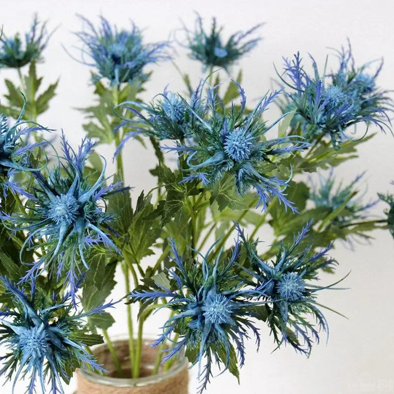 Artificial plants with blue flowers and green leaves on a white background