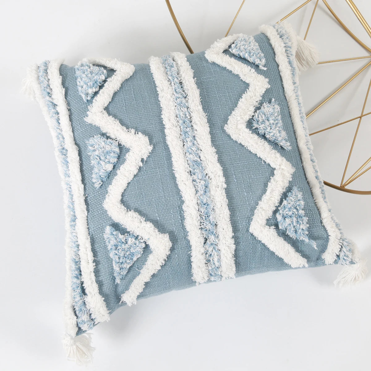 Blue pillow with white zigzag pattern on a white background