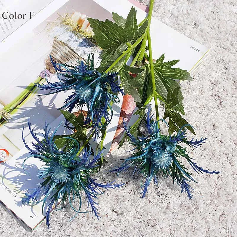 Blue and green artificial flowers on a textured surface