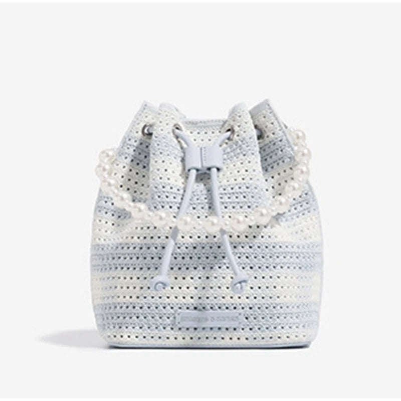 Crocheted bucket bag with pearl embellishments on a white background