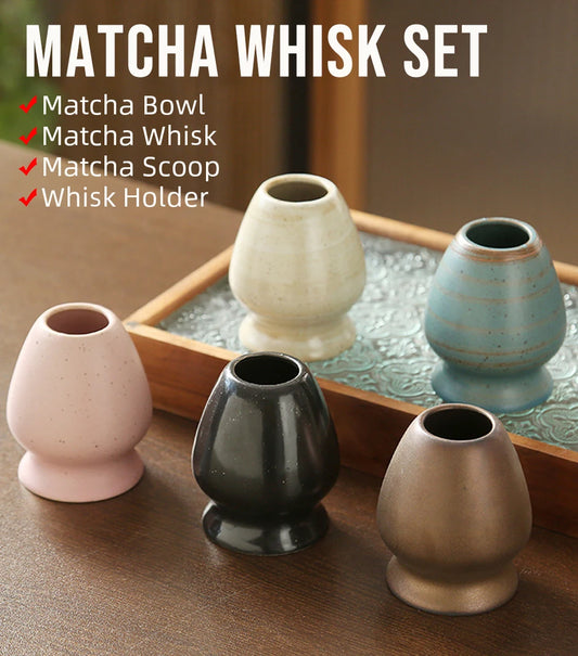 Matcha whisk set with four ceramic containers on a wooden tray.