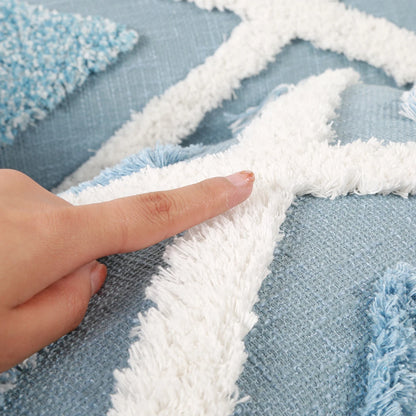 Close-up of a hand pointing at a textured blue and white fabric pattern.
