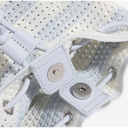 Close-up of a white sneaker with a brand logo on the side.