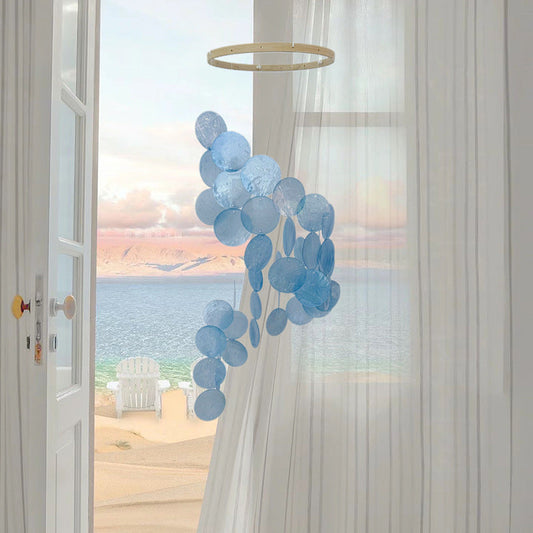 Decorative blue balloon arch in front of a window with a view of the ocean.