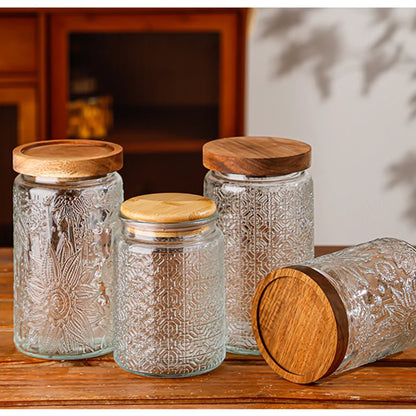 Set of glass jars with wooden lids on a wooden surface