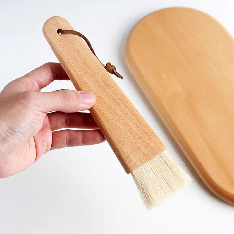 Wooden brush with bristles held by a hand on a white background