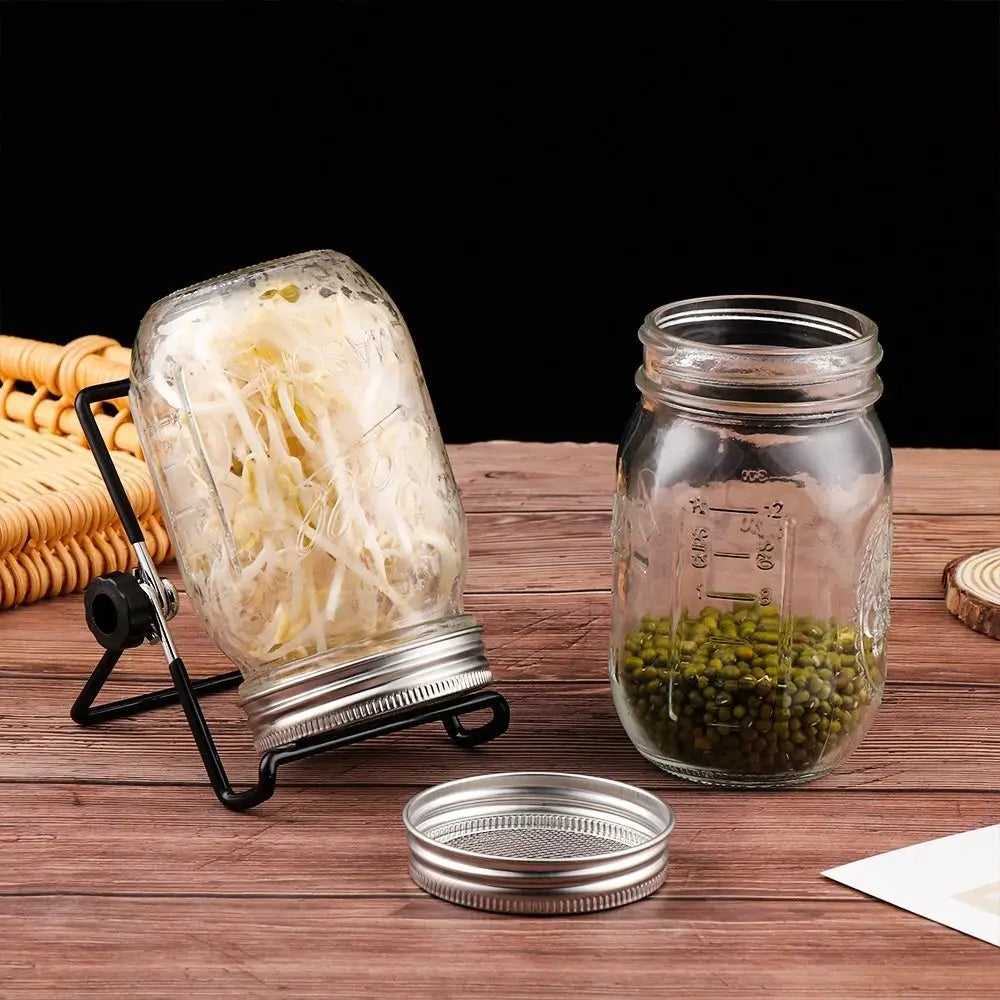 Two glass jars with metal lids on a wooden surface, one containing noodles and the other green beans.