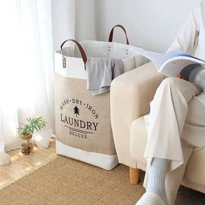Laundry bag labeled 'Laundry Deluxe' next to a person sitting on a chair with a book.