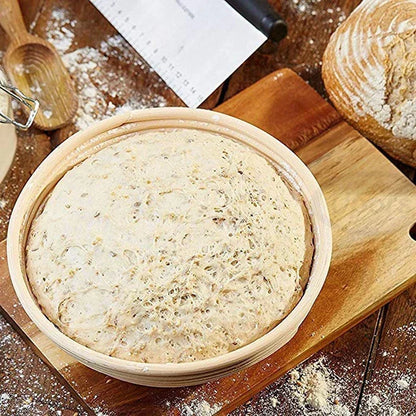 Bread dough in a wooden basket on a wooden table with flour and a knife.