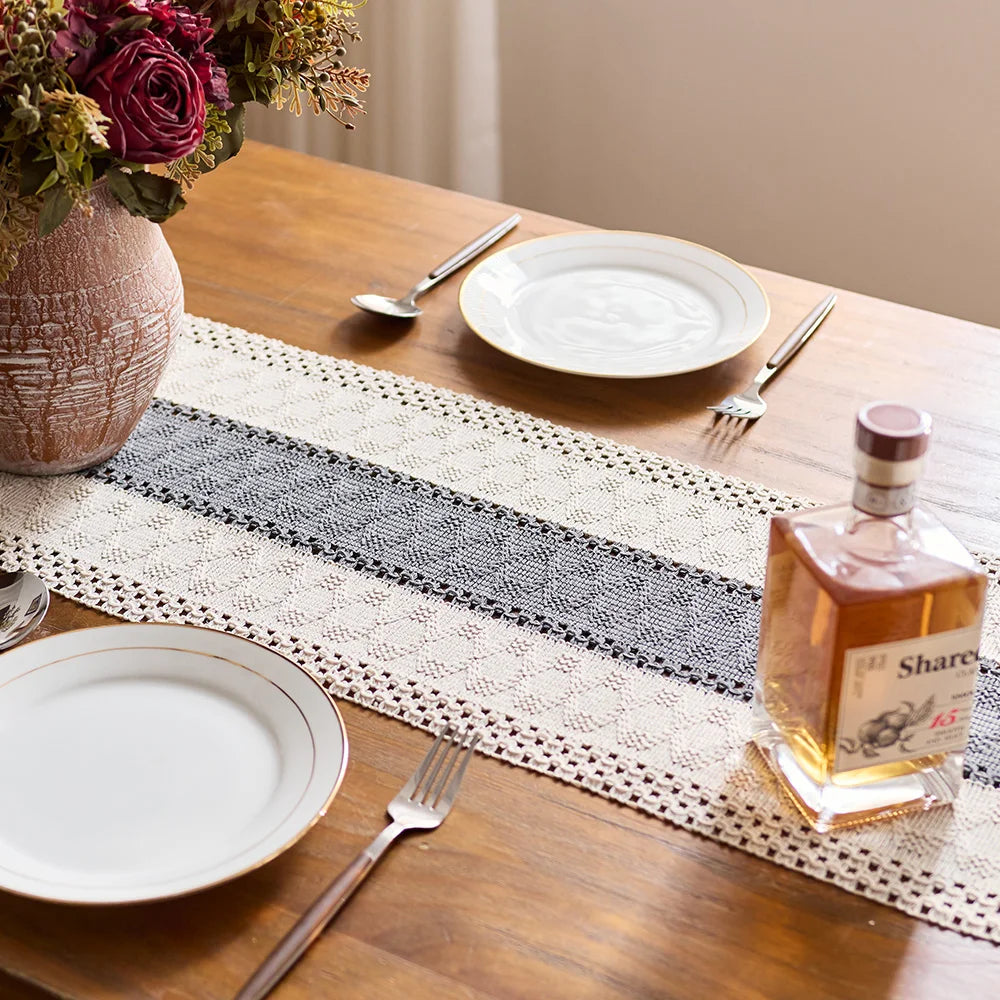 Table setting with plates, cutlery, and a bottle of tequila on a decorative table runner.